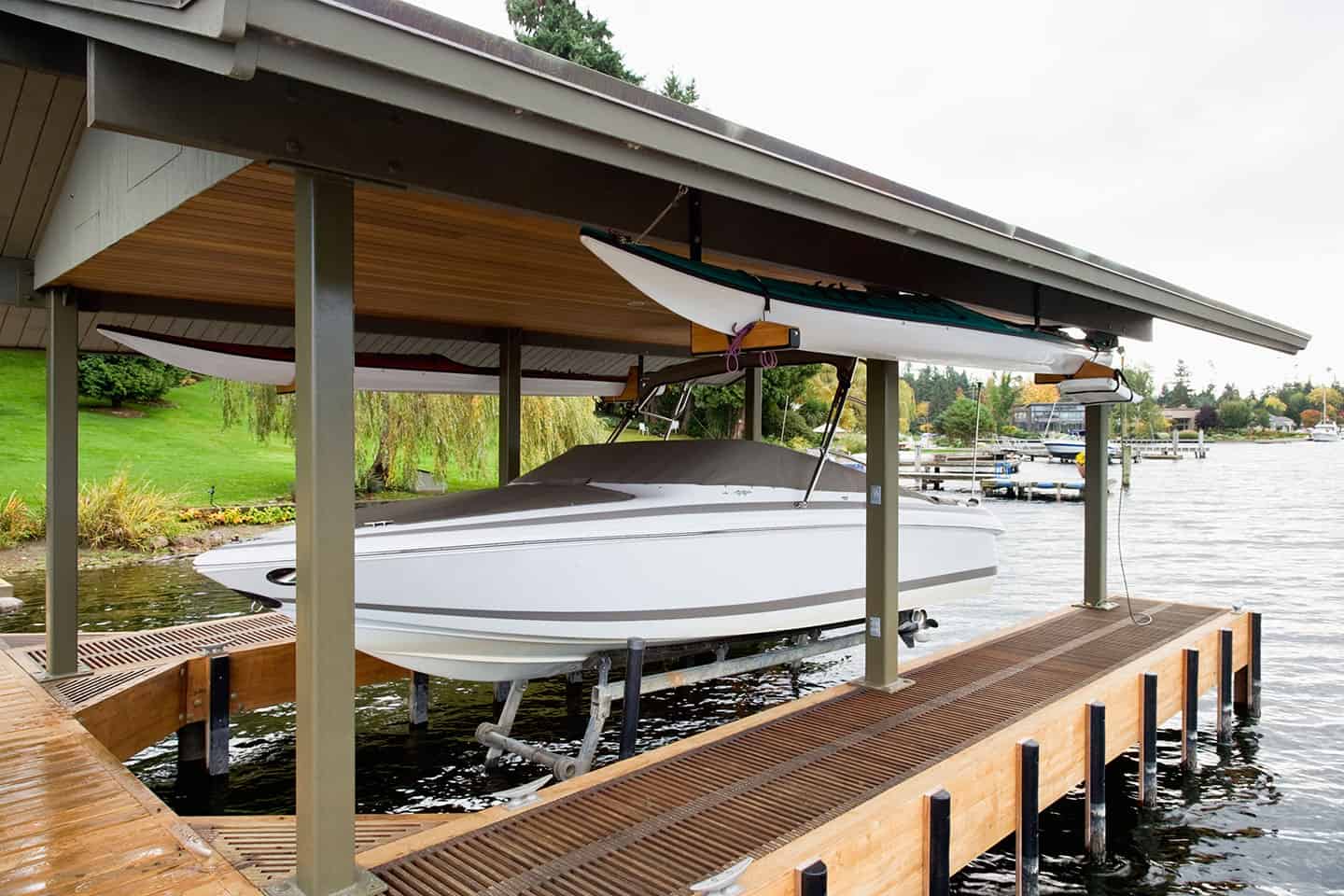 Covered boat dock with lift system holding a white motorboat above the water