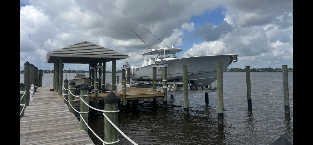 Custom boat lift with sportfishing boat at residential dock in Port St. Lucie, FL.