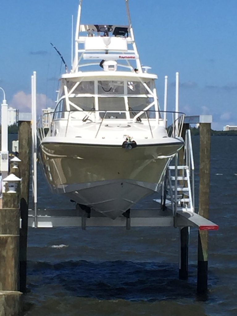 Boat lifted out of the water on a marine hoist at a private dock in Port St. Lucie, Florida